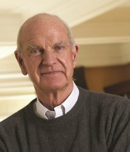 A smiling portrait of Ralph Barford, the Foundation's founder, an older man in a dark sweater and checked collared shirt.